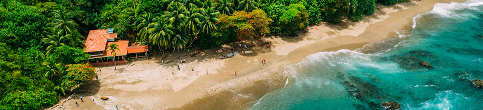 O destinație turistică tropicală, cu o plajă cu nisip și o mare turcoaz.